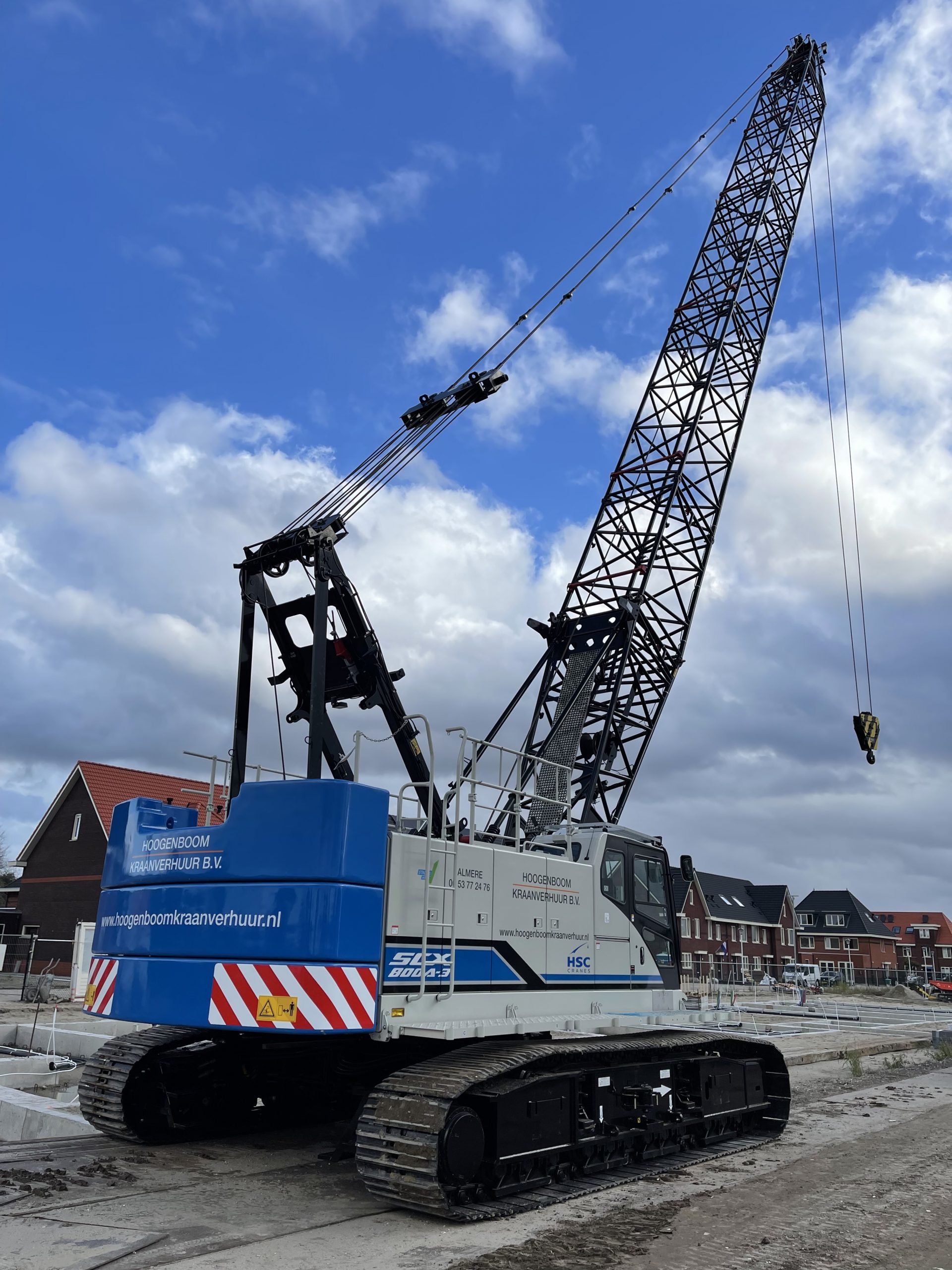 Blauwe Hoogenboom rupskraan met vakwerkgiek op de bouwplaats